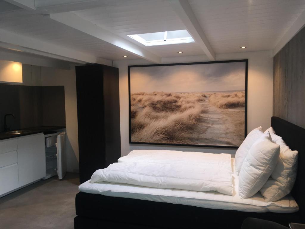una camera da letto con un letto e un dipinto sul muro di Centre beach lodge (2) a Zandvoort
