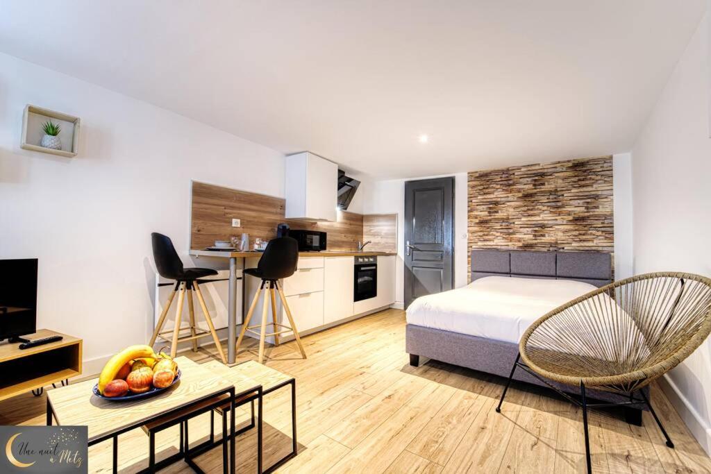 a bedroom with a bed and a table with a bowl of fruit at Mignon Studio au coeur de Metz (unenuitametz) in Metz