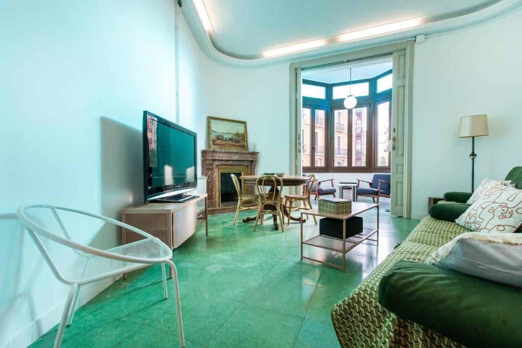 a living room with a couch and a tv at bp1- Piso para Grandes Grupos in Barcelona