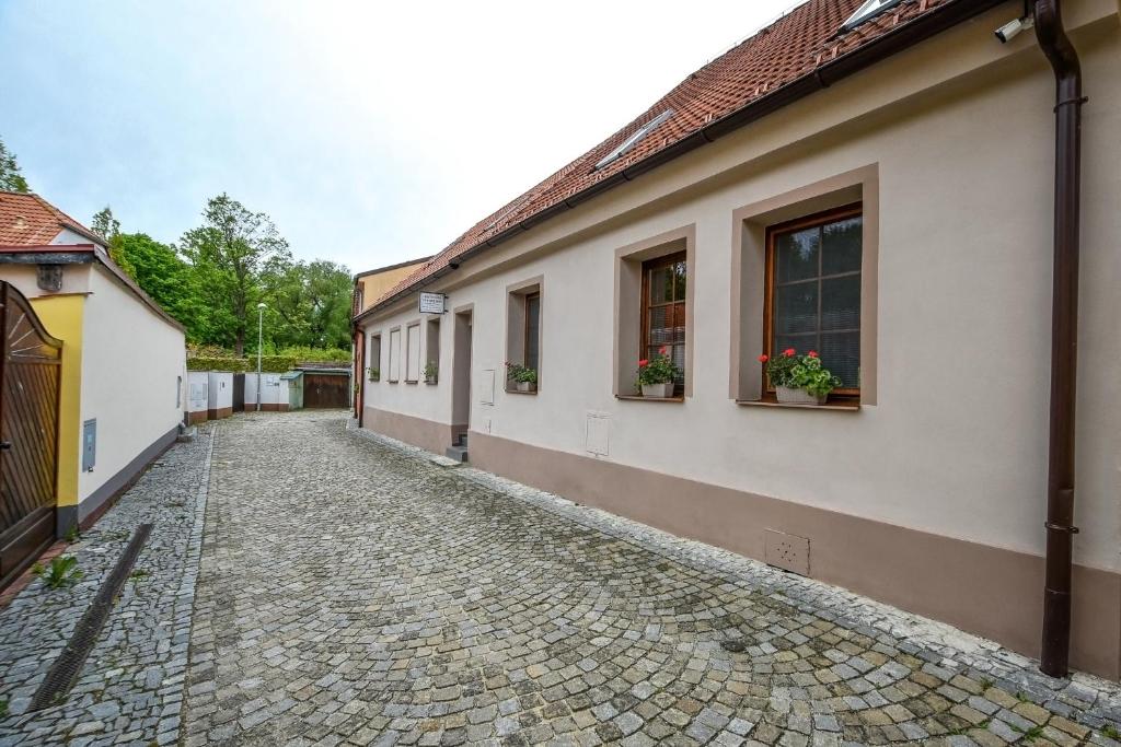 a cobblestone street next to a house with windows at Ubytování Pod Světem-rodinný dům in Třeboň