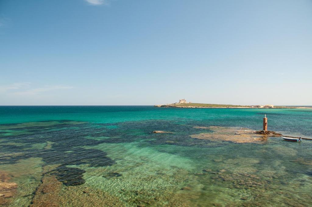 une grande masse d'eau avec un phare dans l'établissement Casa Avola, à Avola