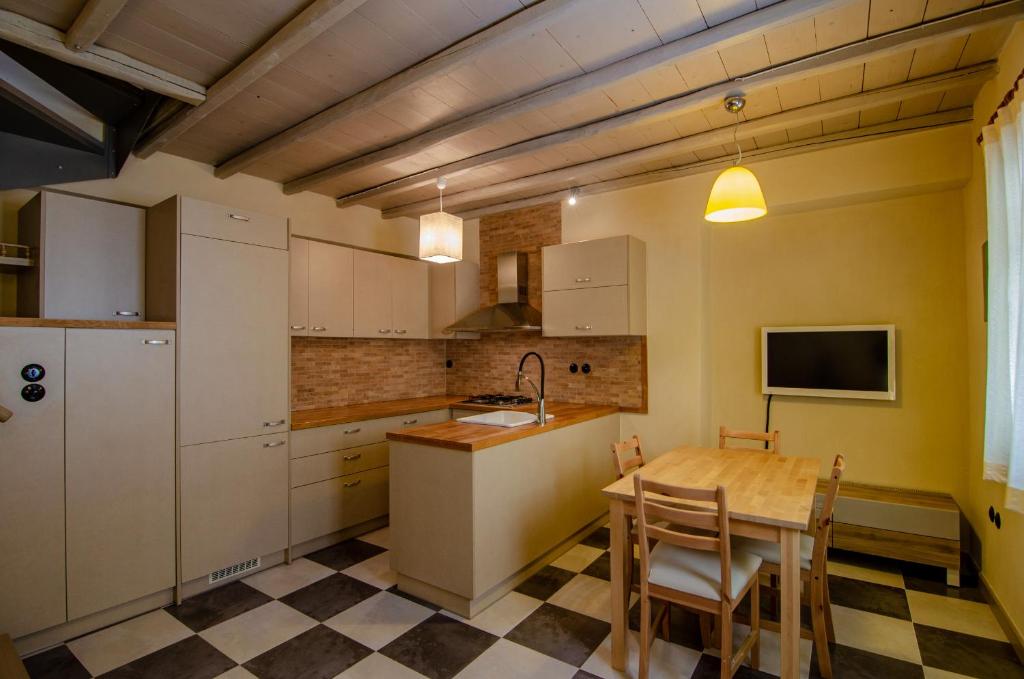 eine Küche mit weißen Schränken, einem Tisch und einem TV in der Unterkunft MyYellowHome in Ermoupoli