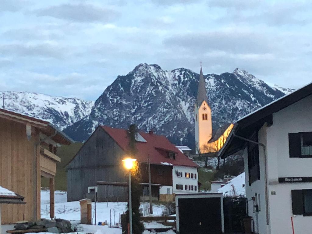 a small town with a church and a mountain at Ferienwohnung Oberstdorf in Oberstdorf