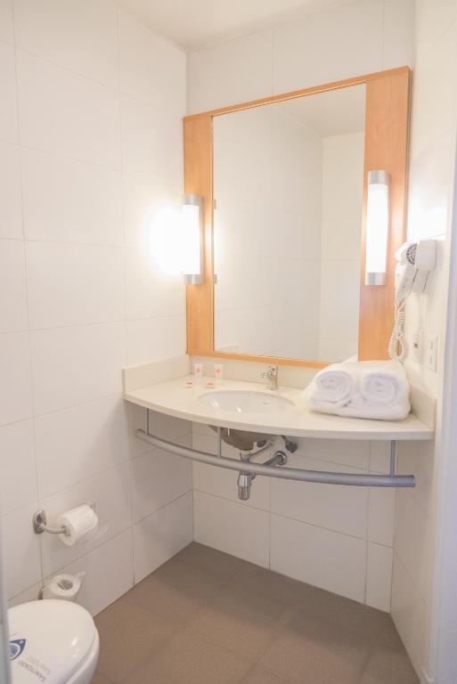 a bathroom with a sink and a mirror and a toilet at ibis Valparaiso in Valparaíso