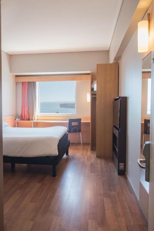 a hotel room with a bed and a window at ibis Valparaiso in Valparaíso