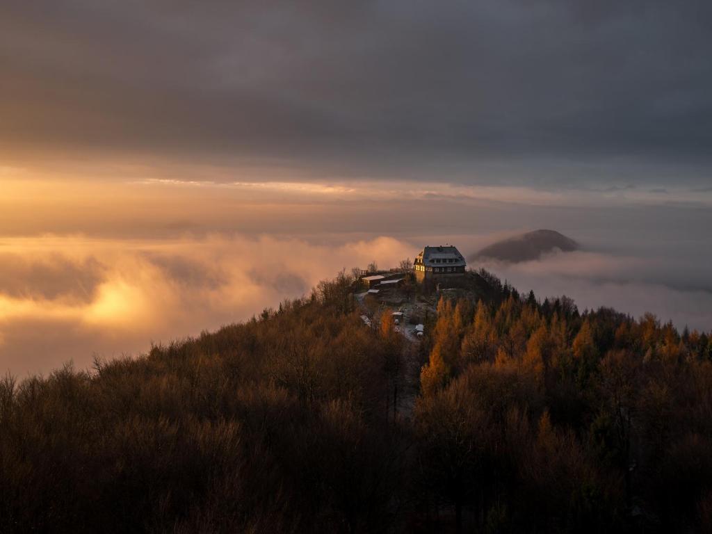 a house on top of a hill in the clouds at Hochwaldbaude in Hain