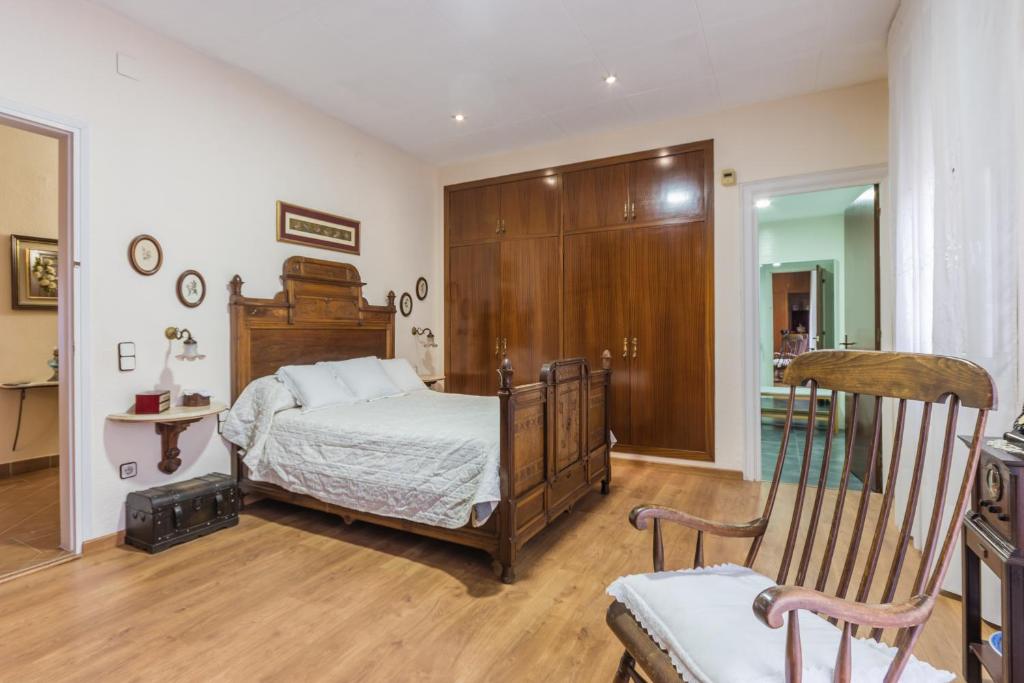 1 dormitorio con 1 cama y armario de madera en Habitaciones en Villa Coliving Masía Rural, en Sant Fost de Campsentelles