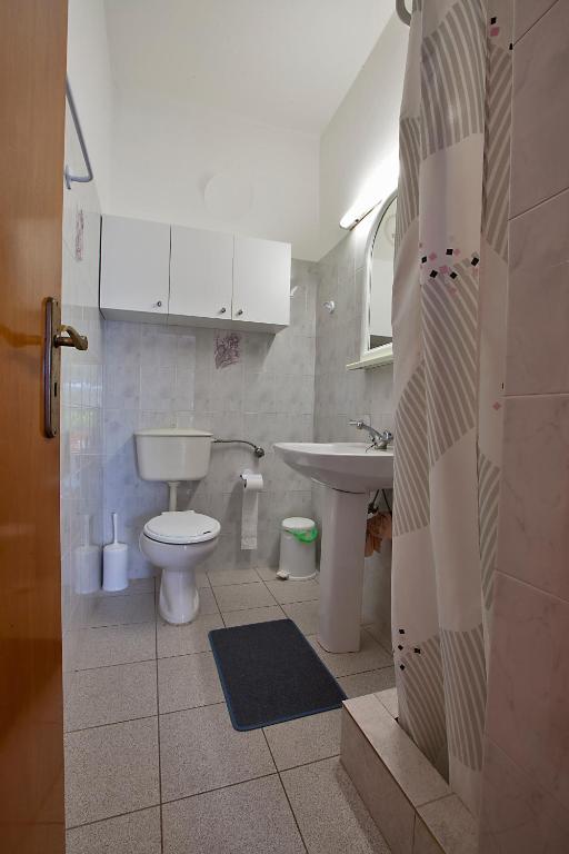 łazienka z toaletą i umywalką w obiekcie Drimouras Apartments w mieście Xiropigado