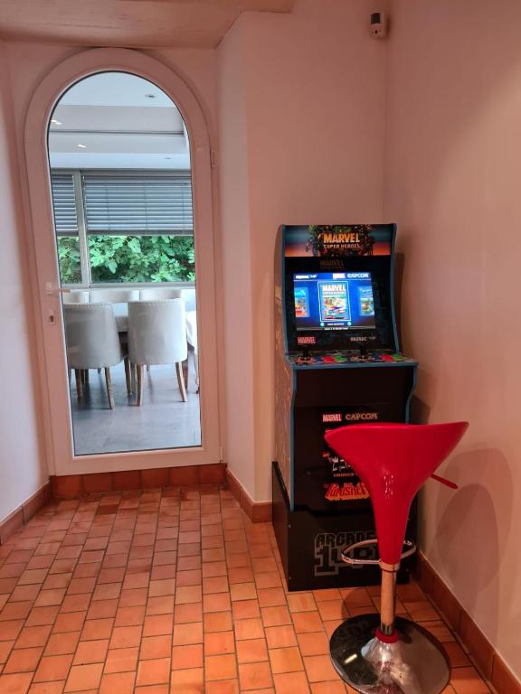 a room with a video game console and a red stool at Maison de vacances Daumeray in Daumeray