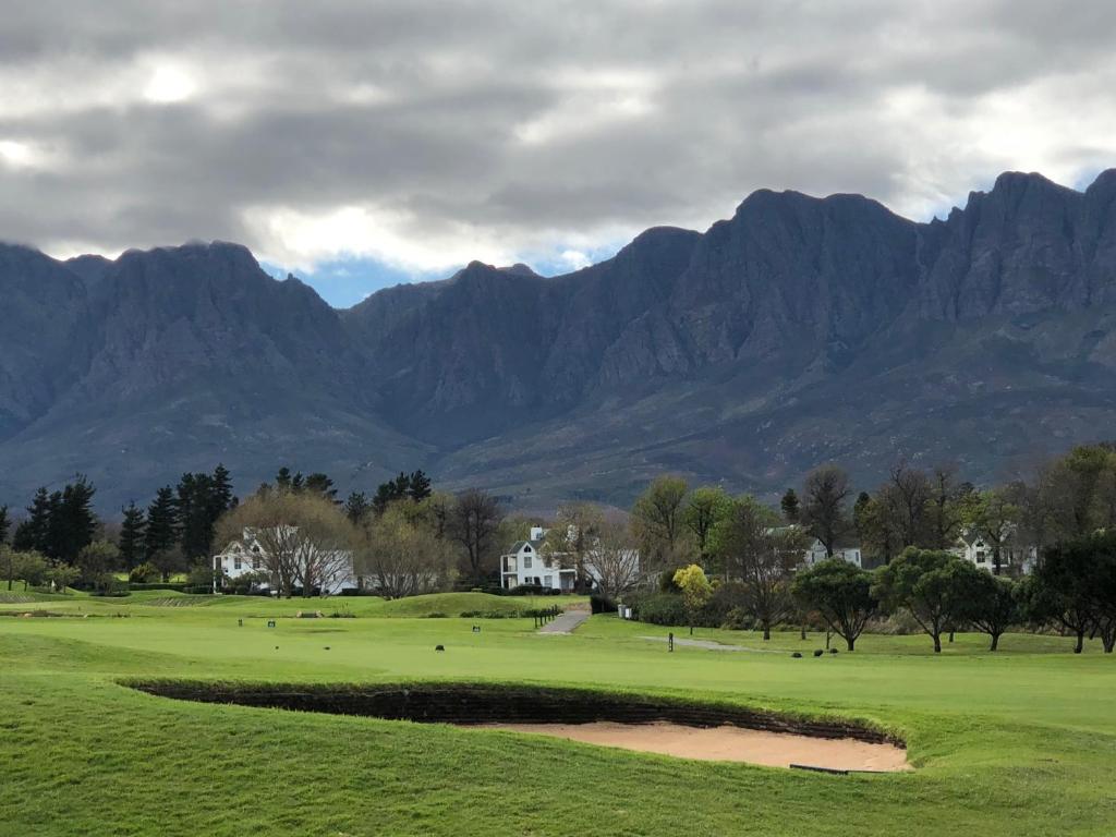 a view of a golf course with mountains in the background at Erinvale Apartment on Erinvale Golf and Country Estate, Somerset West, Westkaap in Cape Town