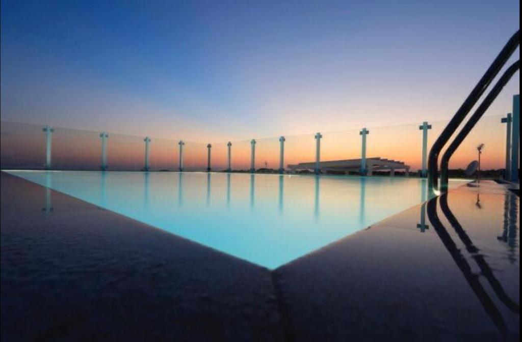una piscina de agua con una puesta de sol en el fondo en Residence Valentina Int 5, en Santa Maria al Bagno