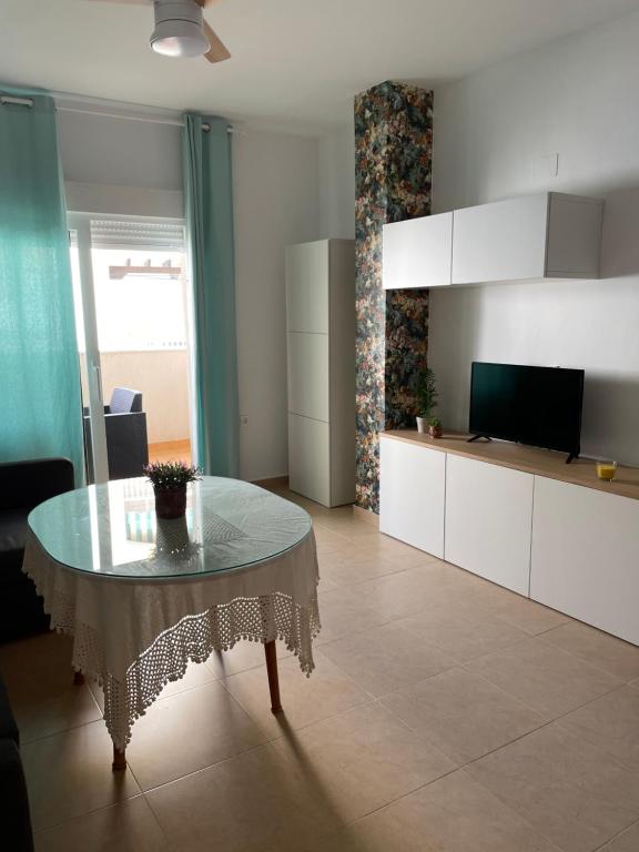 a living room with a table and a television at Apartamento Playa de la Guardia in Salobreña