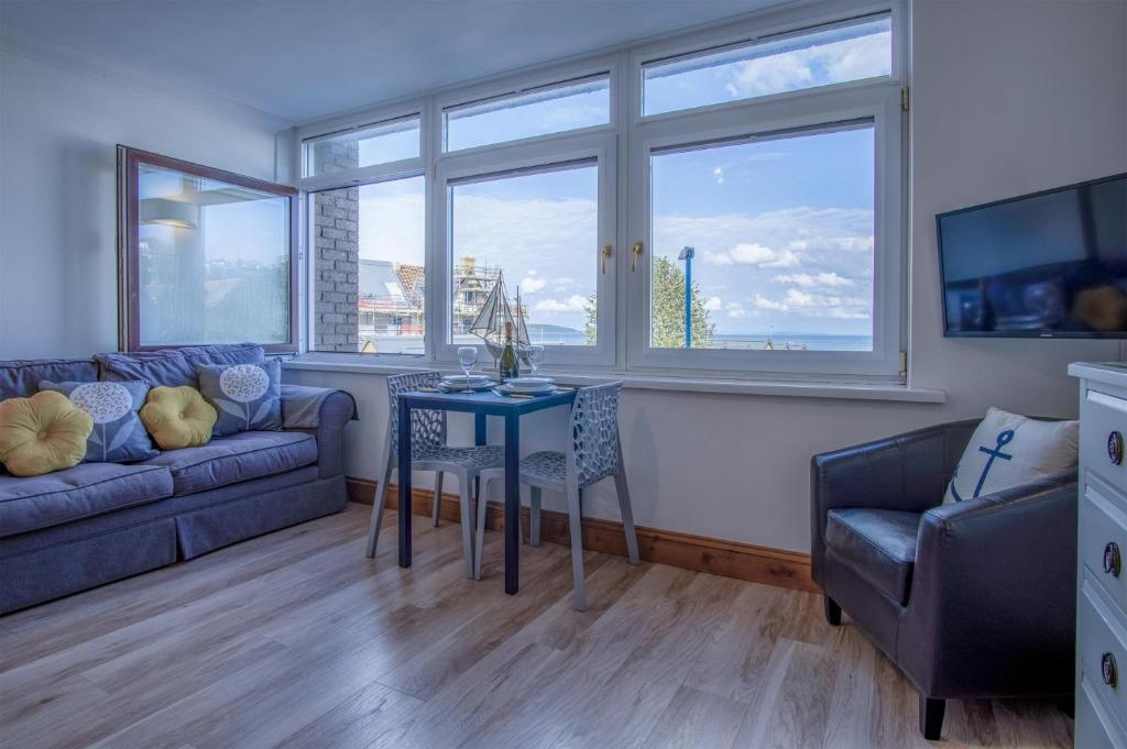 Ocean View - 1 Bedroom Apartment - Saundersfoot في ساندرزفوت: غرفة معيشة مع طاولة وأريكة