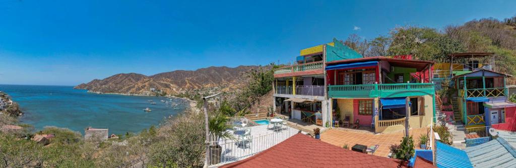 Tayrona Colors Hostel في تاجانجا: مجموعة من المنازل على تلة بجوار المحيط