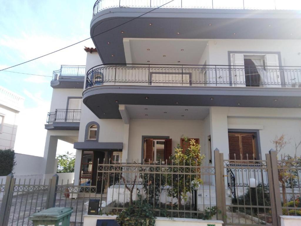 Cette maison blanche dispose d'un balcon. dans l'établissement Tiffany's 5' min from airport, à Spáta