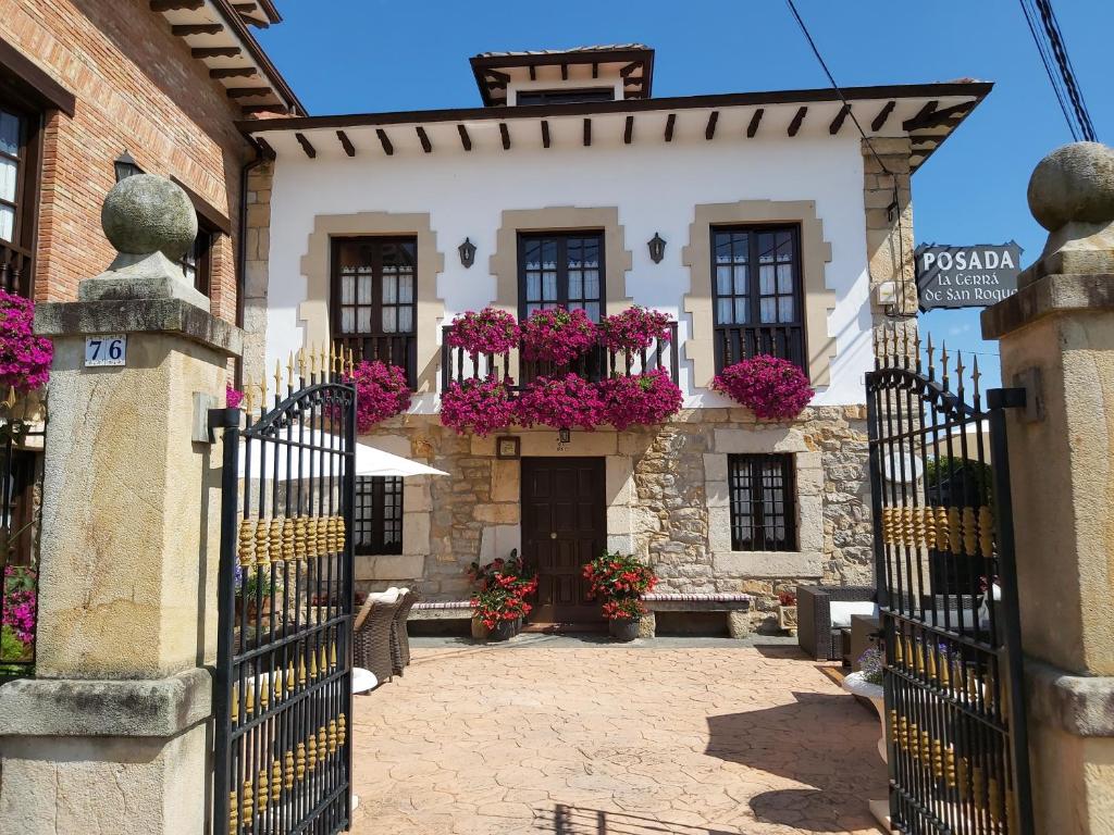 Una puerta a un edificio con flores. en Posada La Cerra de San Roque en Santillana del Mar
