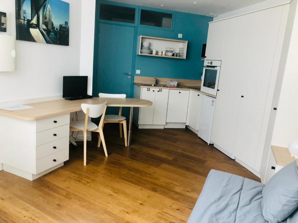 - une cuisine avec un bureau et une table dans une chambre dans l'établissement L'athlétique - 033, à Rouen