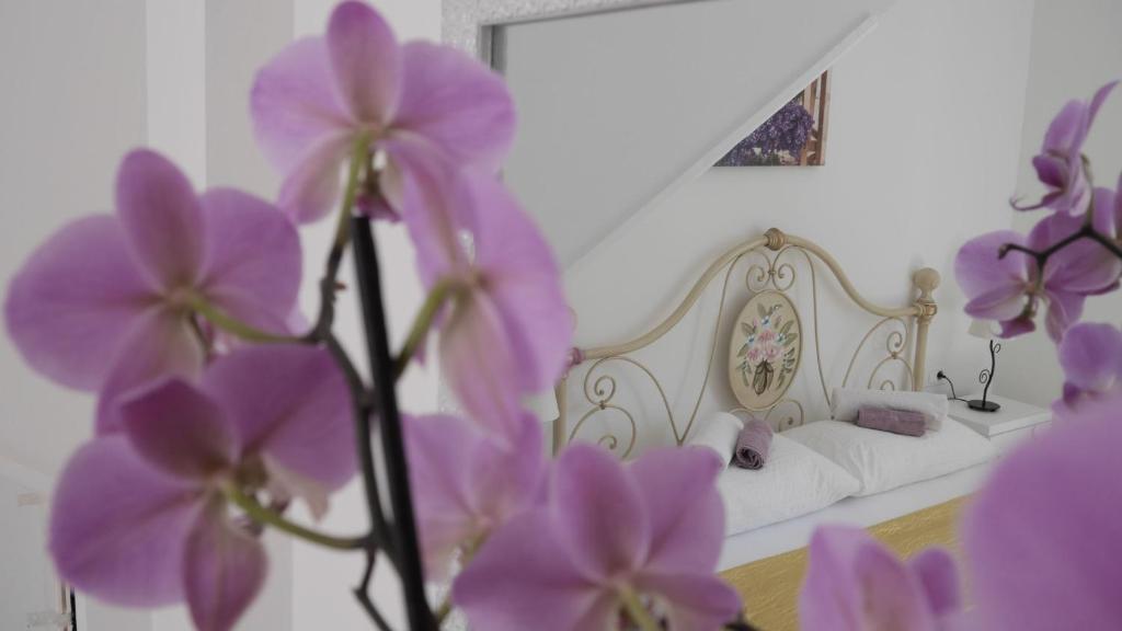 um quarto com uma cama com flores roxas em Villa Claudia em Fažana