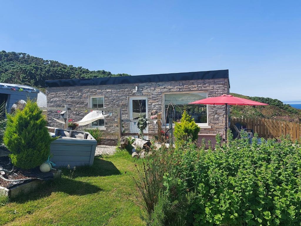 a brick house with an umbrella in a yard at Hillside Cottage in Letterkenny