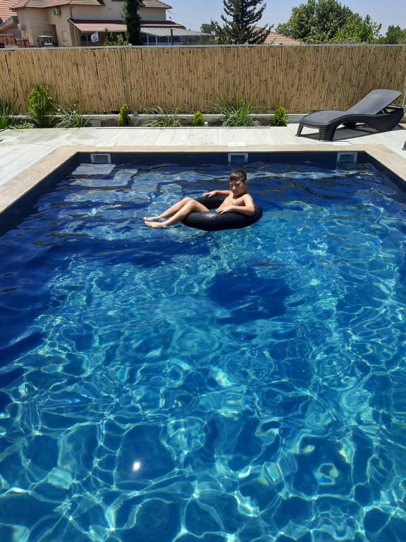 a woman laying in a swimming pool at רוח ברמה in Bruchim Qela' Alon