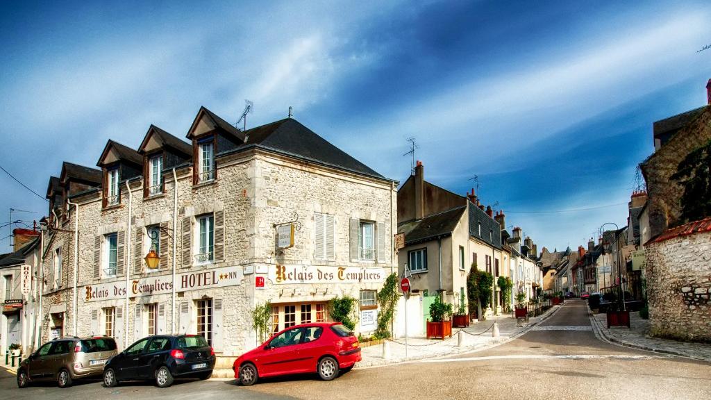 a red car parked in front of a building at Le Relais Des Templiers in Beaugency