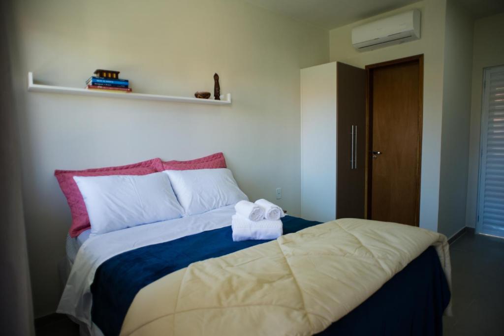 a bedroom with a bed with a towel on it at Pousada Vila da Praia in Maricá