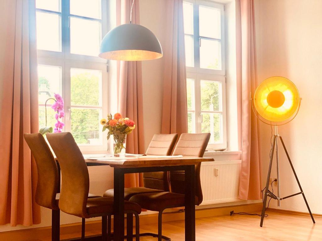 einen Esstisch mit Stühlen und einer Lampe in der Unterkunft Domblick in Erfurt