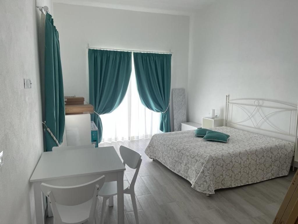 a bedroom with a bed and a table and a desk at VILLA IRMA in Varigotti