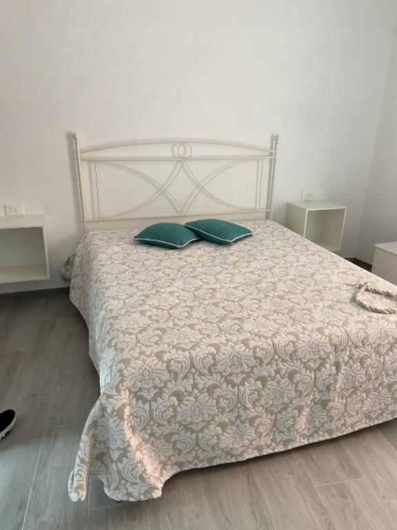 a white bed with two green pillows on it at VILLA IRMA in Varigotti
