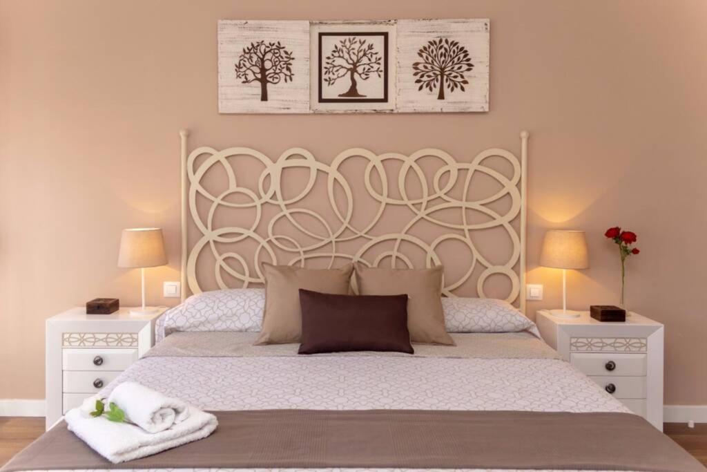聖馬丁德拉維加的住宿－La Casa de Silvia Visita Parque Warner, Madrid y alrededores，一间卧室配有一张带2个床头柜的大型白色床
