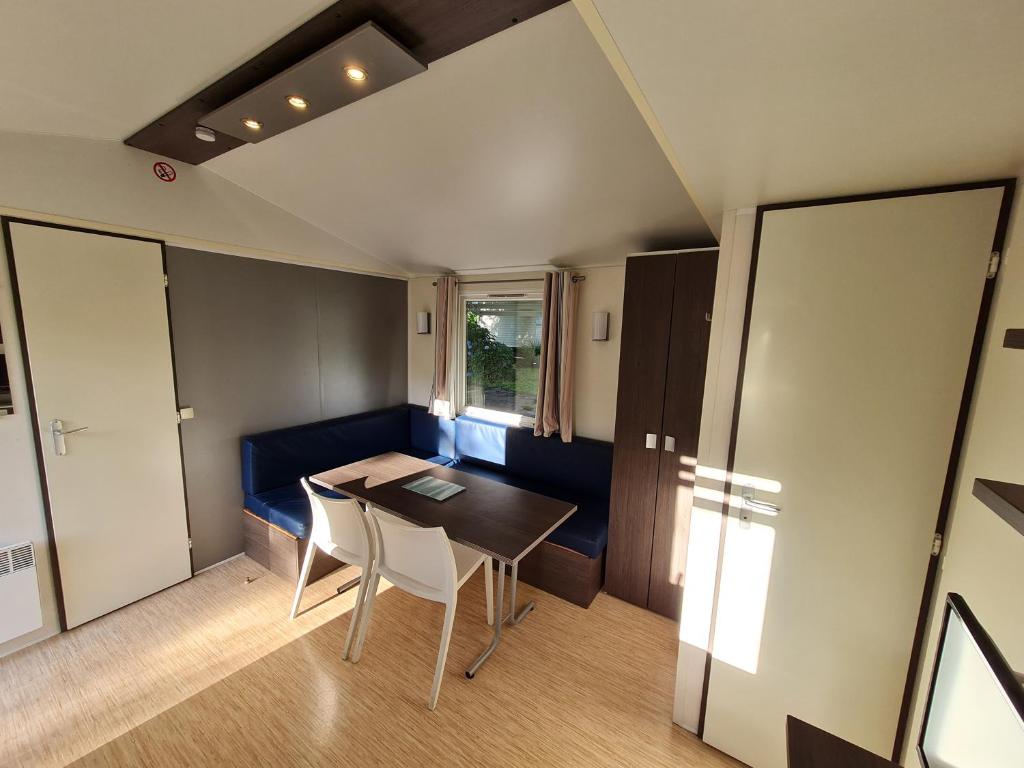 a small dining room with a table and chairs at L'Orangerie de Lanniron - Mobil-Home O'HARA privilège - 3 chambres - 6 pers in Quimper