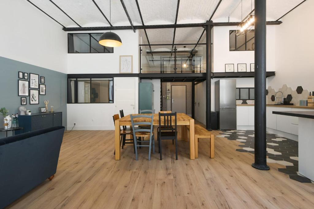 - une cuisine et une salle à manger avec une table et des chaises dans l'établissement Beautiful loft in a former factory in Tourcoing - Welkeys, à Tourcoing
