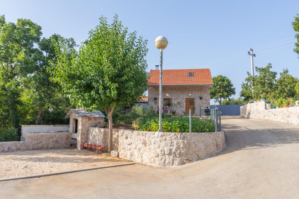 una casa con un albero e un muro di pietra di Vintage Kuzina a Poljica