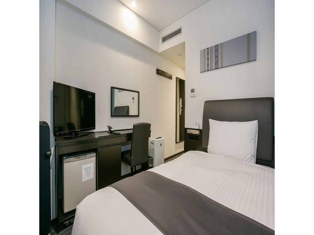 a bedroom with a bed and a desk and a television at Mars Garden Hotel Hakata - Vacation STAY 48738v in Fukuoka