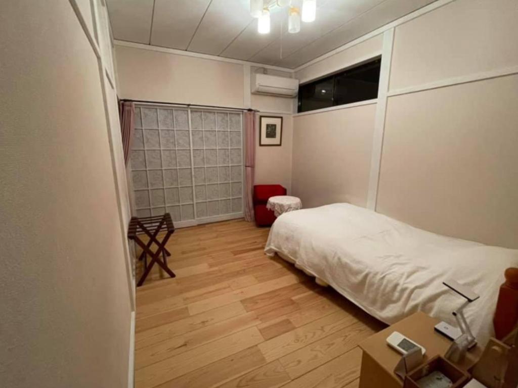 B&B Ladies Only Grape mama Peach room - Vacation STAY 11708 في Koshu: غرفة نوم بسرير ومكتب ونافذة