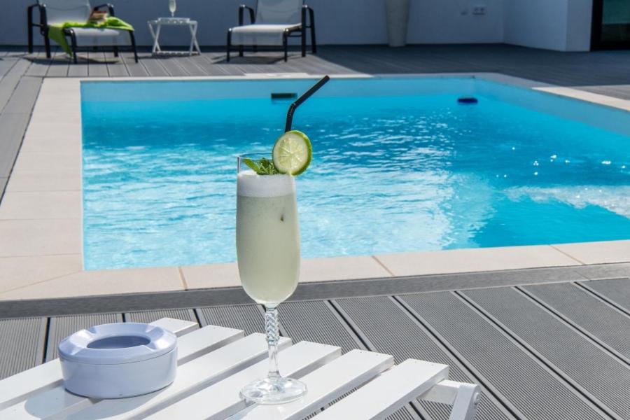 a drink sitting on a table next to a swimming pool at Villa Santiago in Lajares