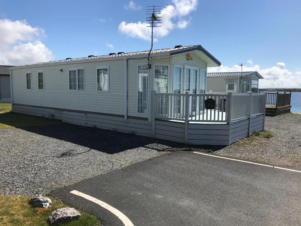 a white house sitting in a parking lot at Port Haverigg Millom in Millom