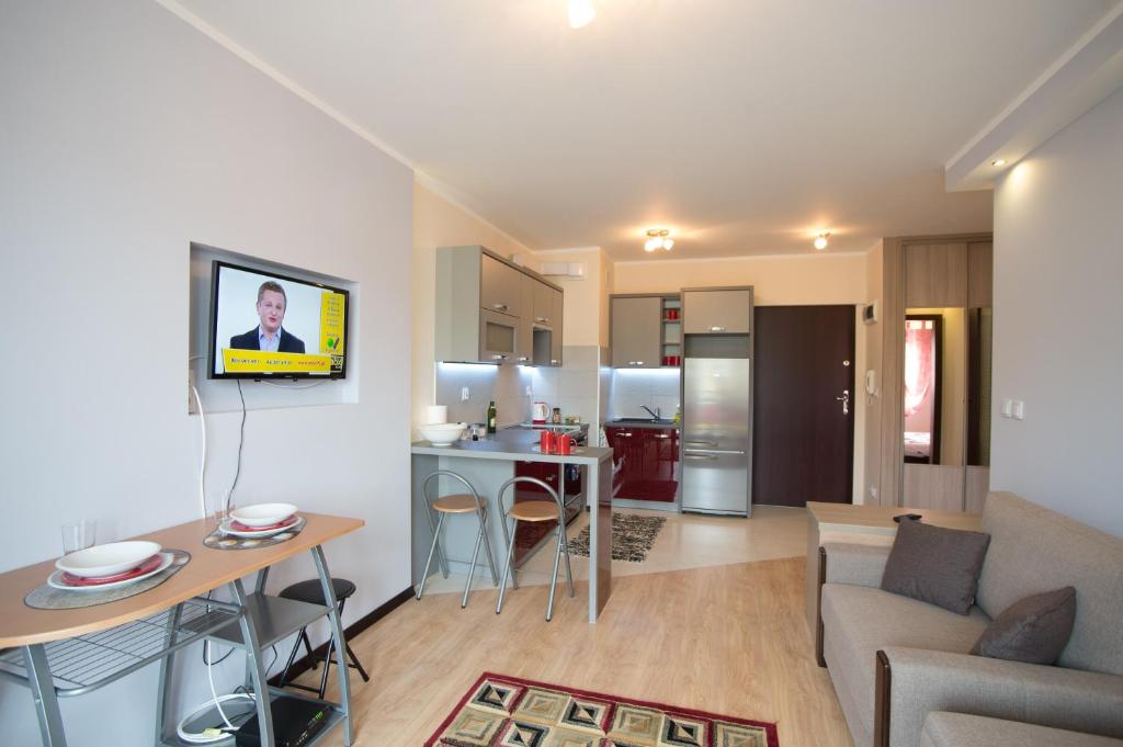 a living room and kitchen with a couch and a table at Słoneczny Apartament in Giżycko