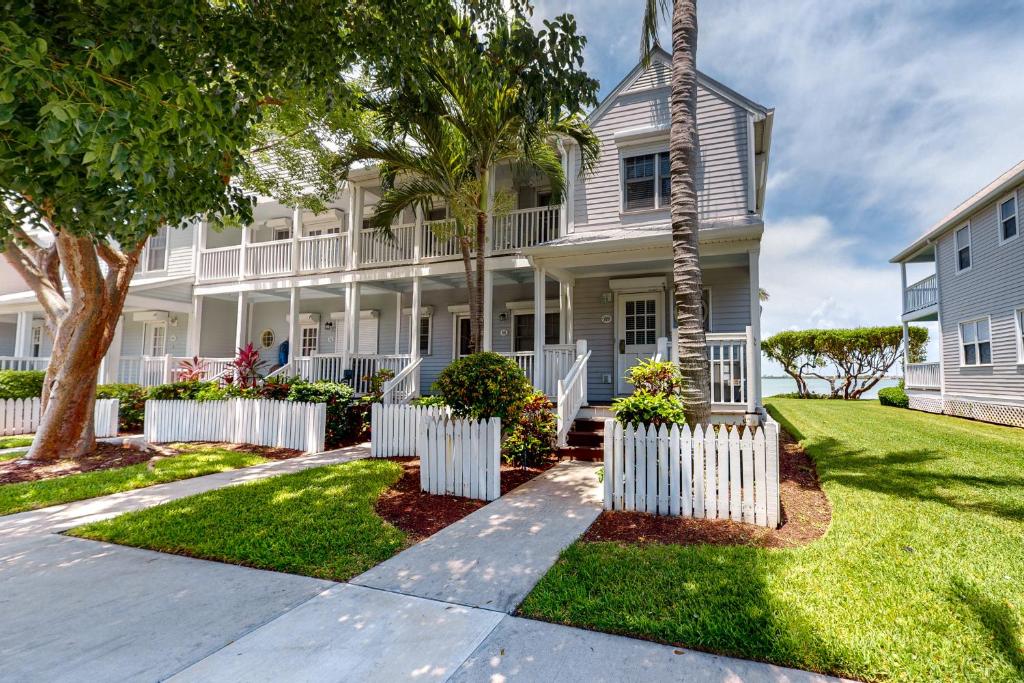 a white house with a white picket fence at Palm Breeze in Duck Key