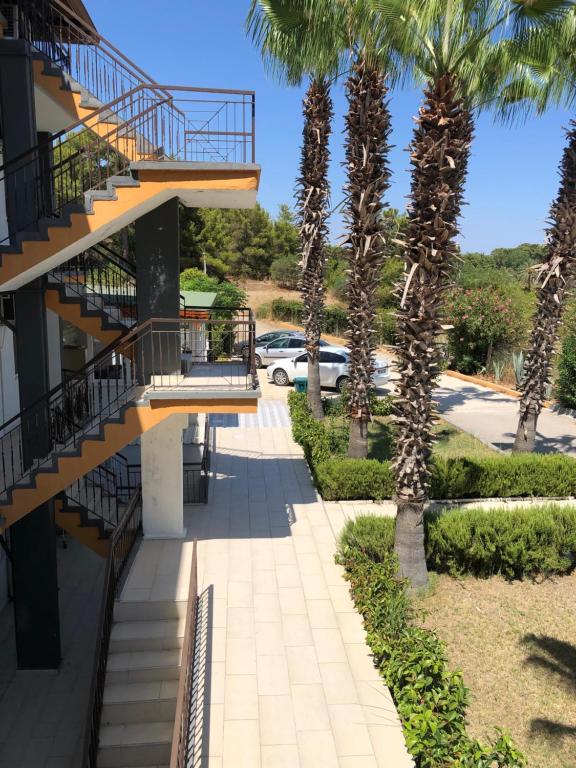 een loopbrug voor een gebouw met palmbomen bij MİNA GRAND HOTEL in Kemer