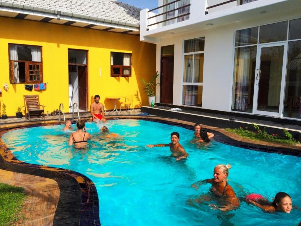 a group of people swimming in a swimming pool at Romeo and Juliet Guest House in Negombo