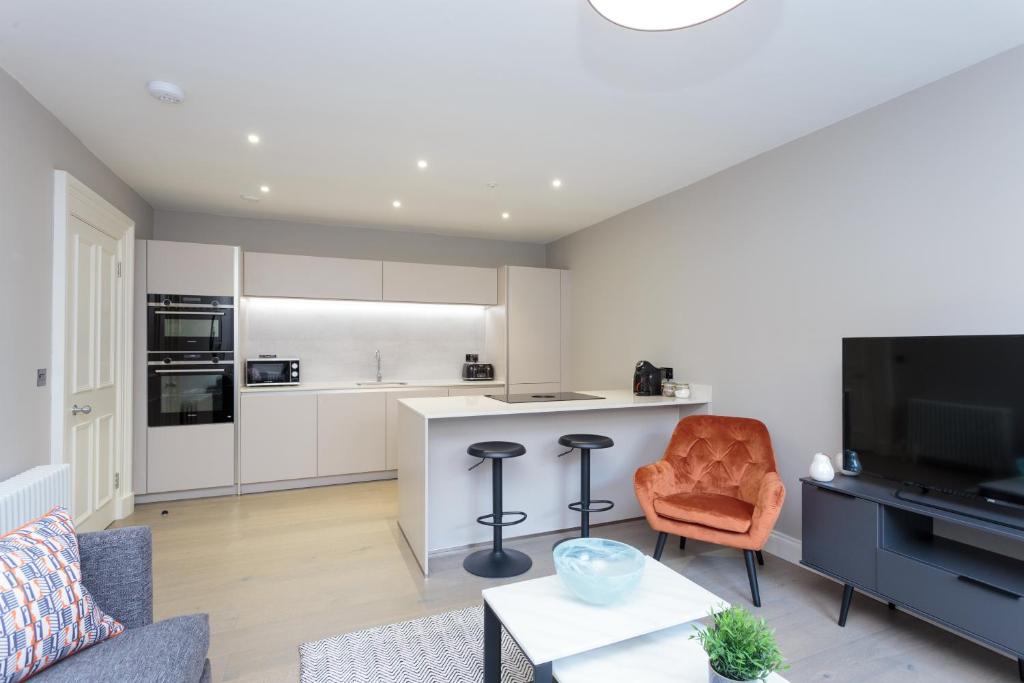een woonkamer met een bank en een keuken bij Dragon Suites - Edinburgh City Centre 1 Bed Apartment in Edinburgh