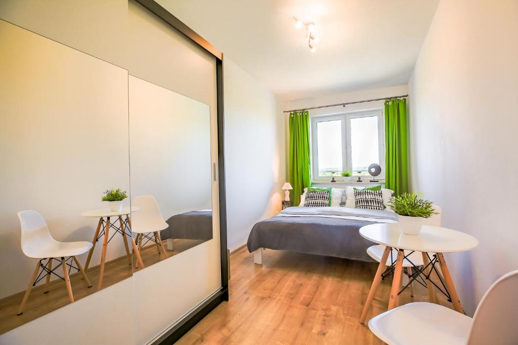 Schlafzimmer mit einem Bett und einem Spiegel in der Unterkunft Apartament Comfort in Suwałki