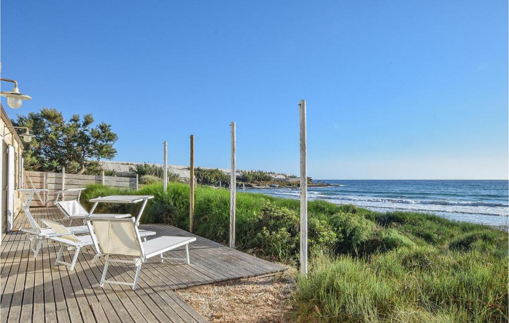 leżak z krzesłami i ocean w tle w obiekcie Beautiful Home In Siracusa With Wifi w Syrakuzach