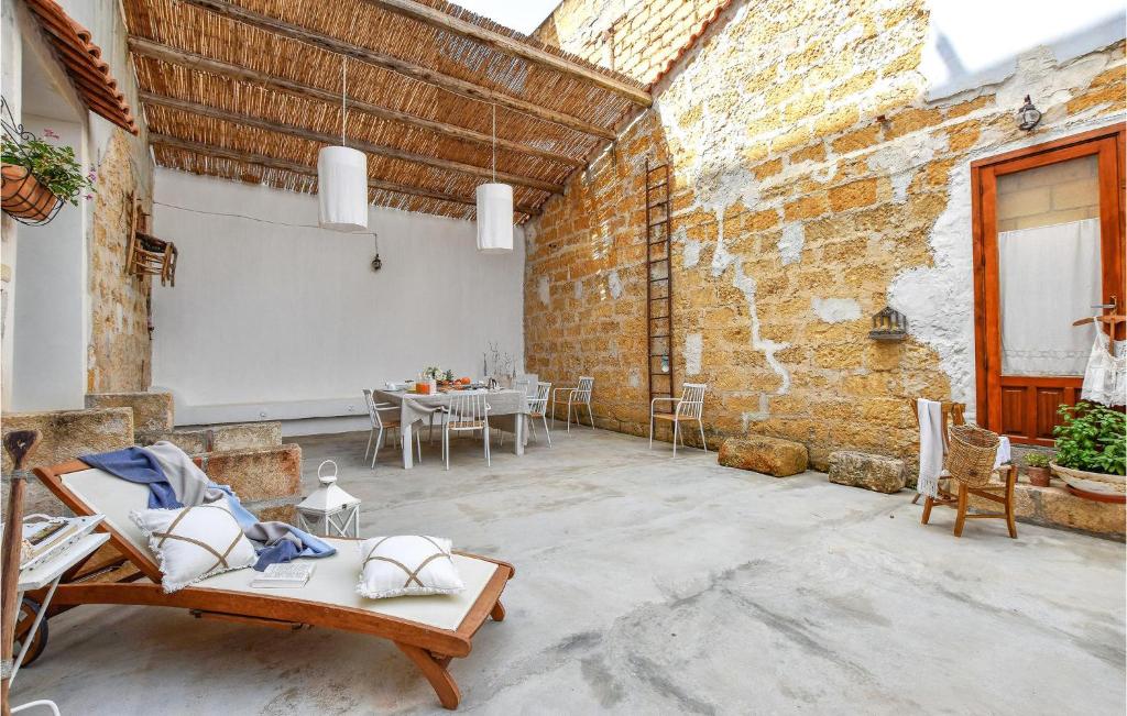 eine Terrasse mit einem Tisch und Stühlen in einer Backsteinmauer in der Unterkunft 2 Bedroom Amazing Apartment In Trappeto in Trappeto