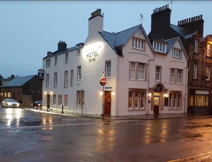 a white building on the corner of a street at Queens Hotel in Stonehaven