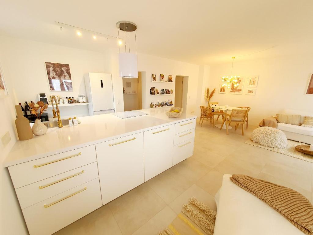 a kitchen with white cabinets and a dining room at DIE ZEIL in Eltville