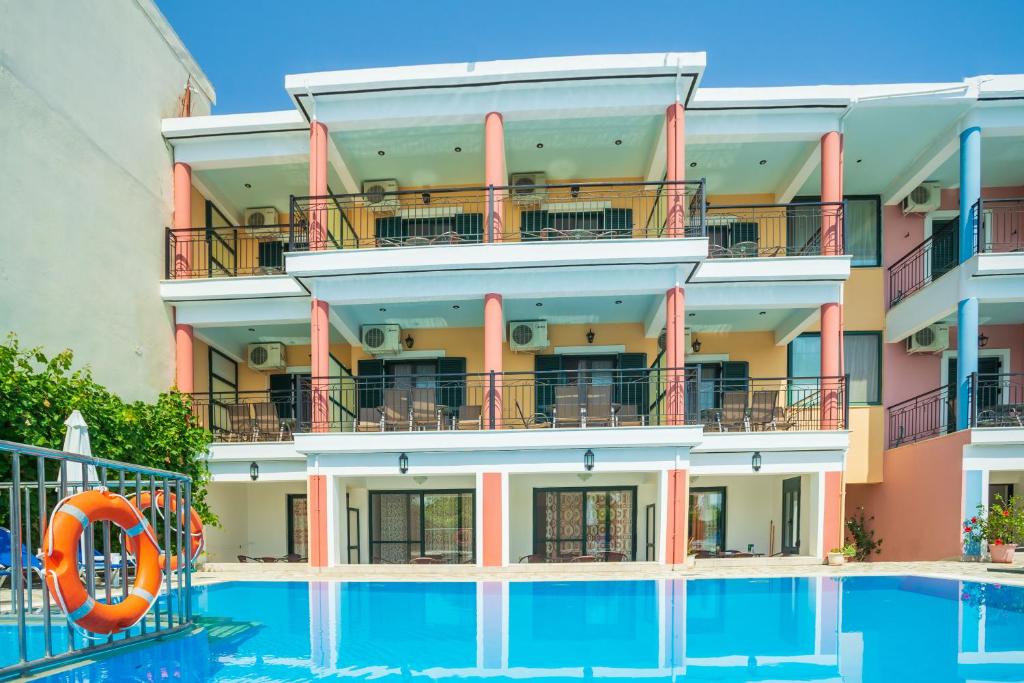 een hotel met een zwembad en een oranje reddingsboei bij Ionion Apartments & Studios in Nydri
