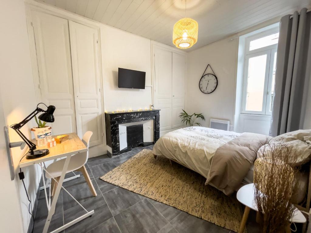 1 dormitorio con cama, escritorio y chimenea en Studio confort proche centre ville / gare, en Valence