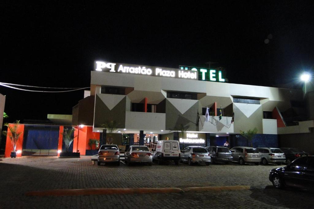 a parking lot in front of a hotel at night at Arrastão Premium Plaza in Muriaé